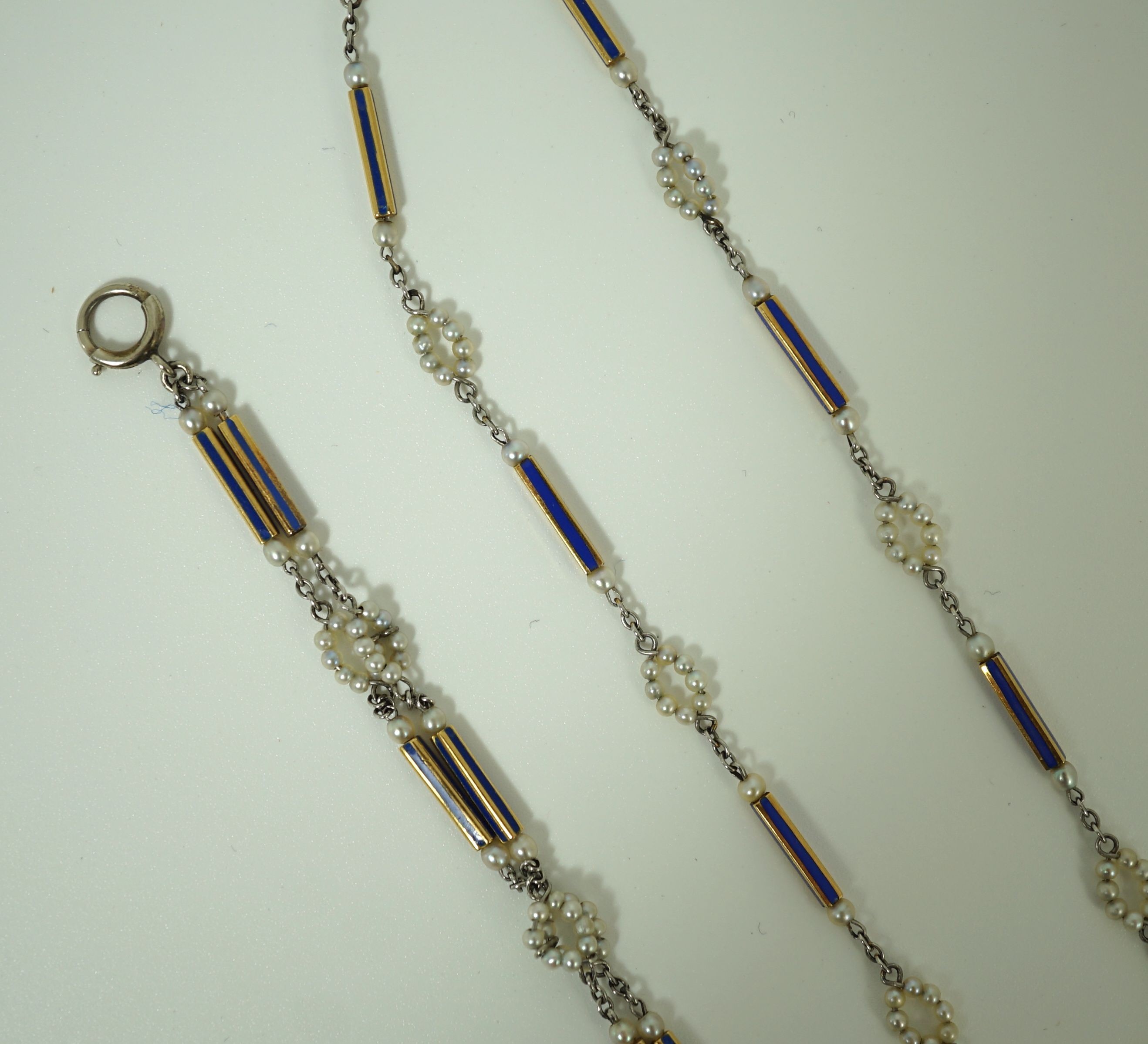 An early 20th century Tiffany & Co platinum, seed pearl and diamond set pendant square open faced dress timepiece, on a platinum, gold, enamel and seed pearl set chain, together with a matching 9ct bracelet and 9ct earri